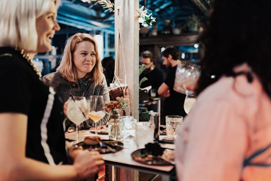 Clients accoudés au comptoir d'un bar en début de soirée